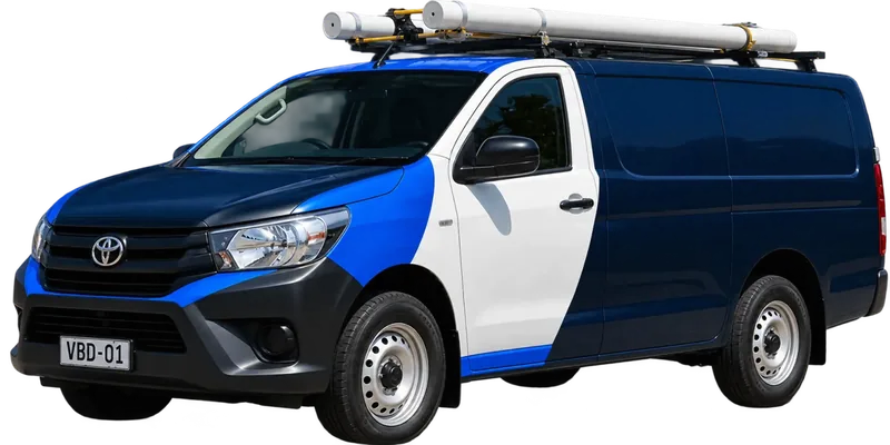 A licensed Richmond plumbing van loaded with pipe on the roof rack